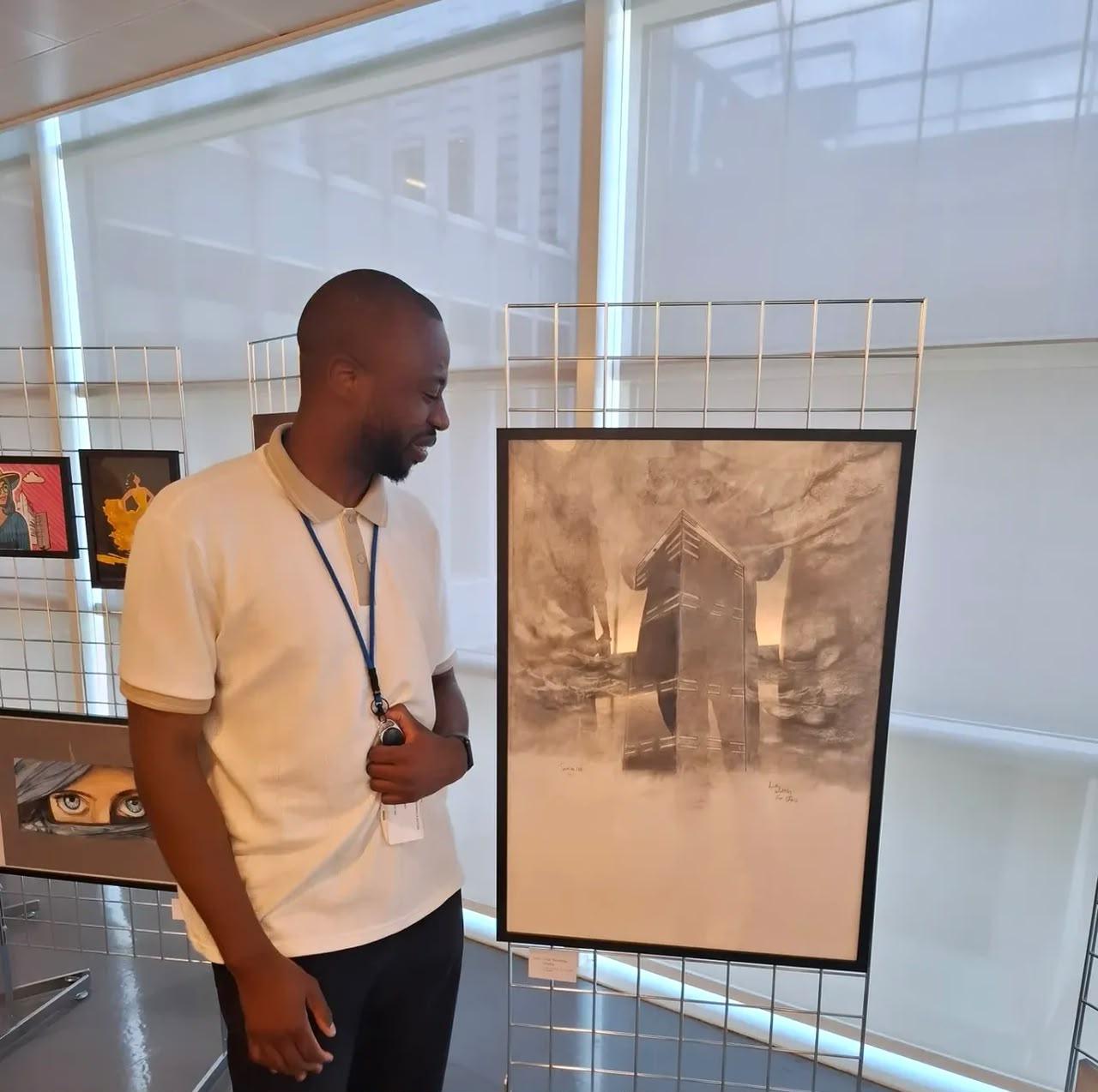 Andy devant son dessin architectural encadré